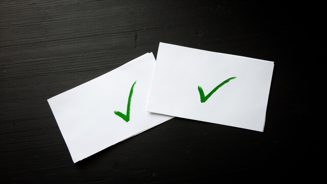 Two index cards on a desk — one labeled with a checkmark, one labeled with an X — summarizing the verdict for each drone