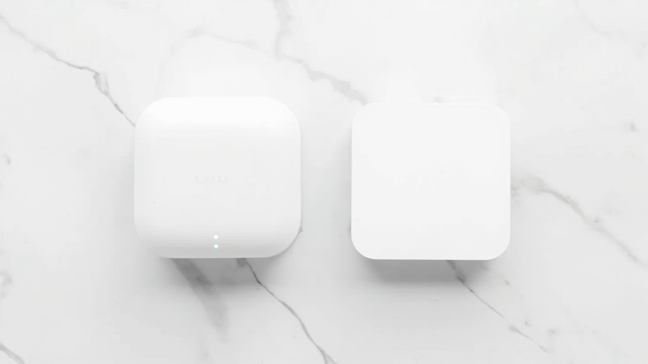 Amazon eero Max 7 and Netgear Orbi 970 mesh nodes placed on a wooden media console with warm evening lighting